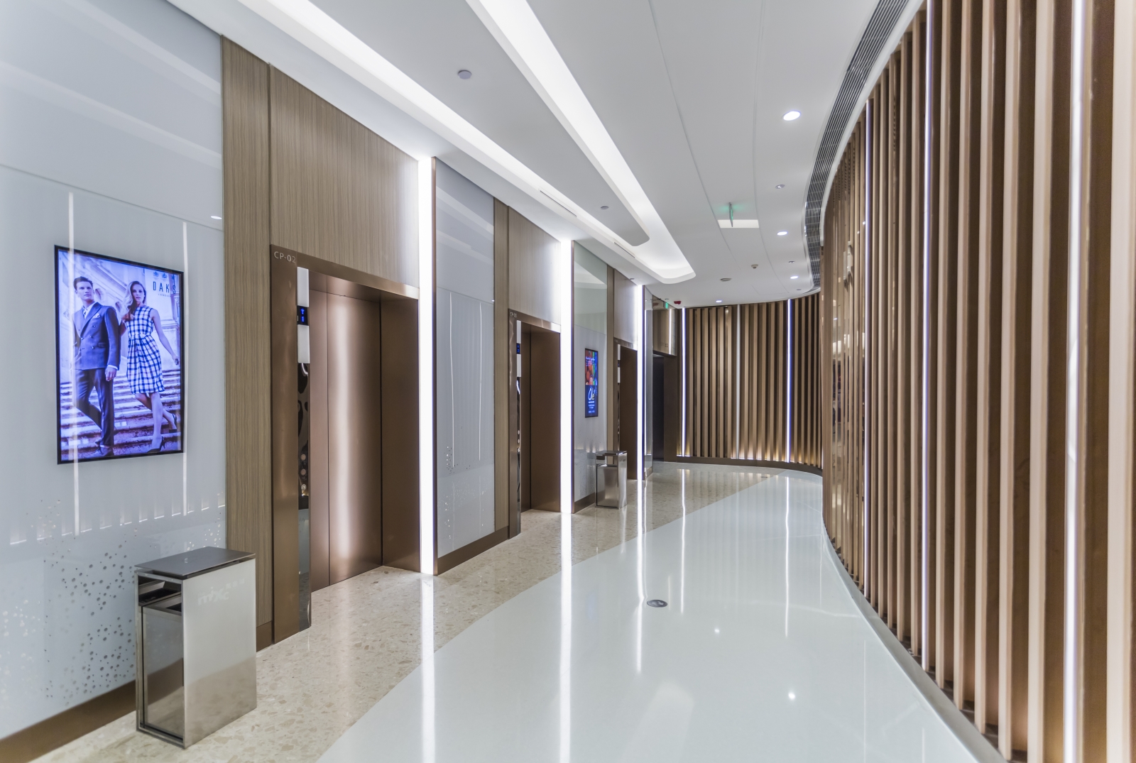 Hall de ascensores con acabados en acero y madera